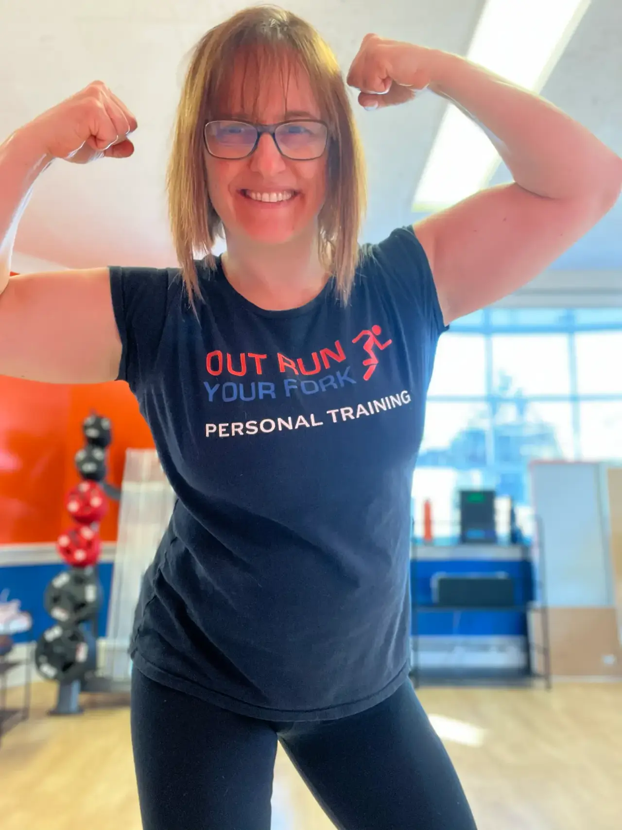 A member in an Out Run Your Fork shirt stretching by the studio window
