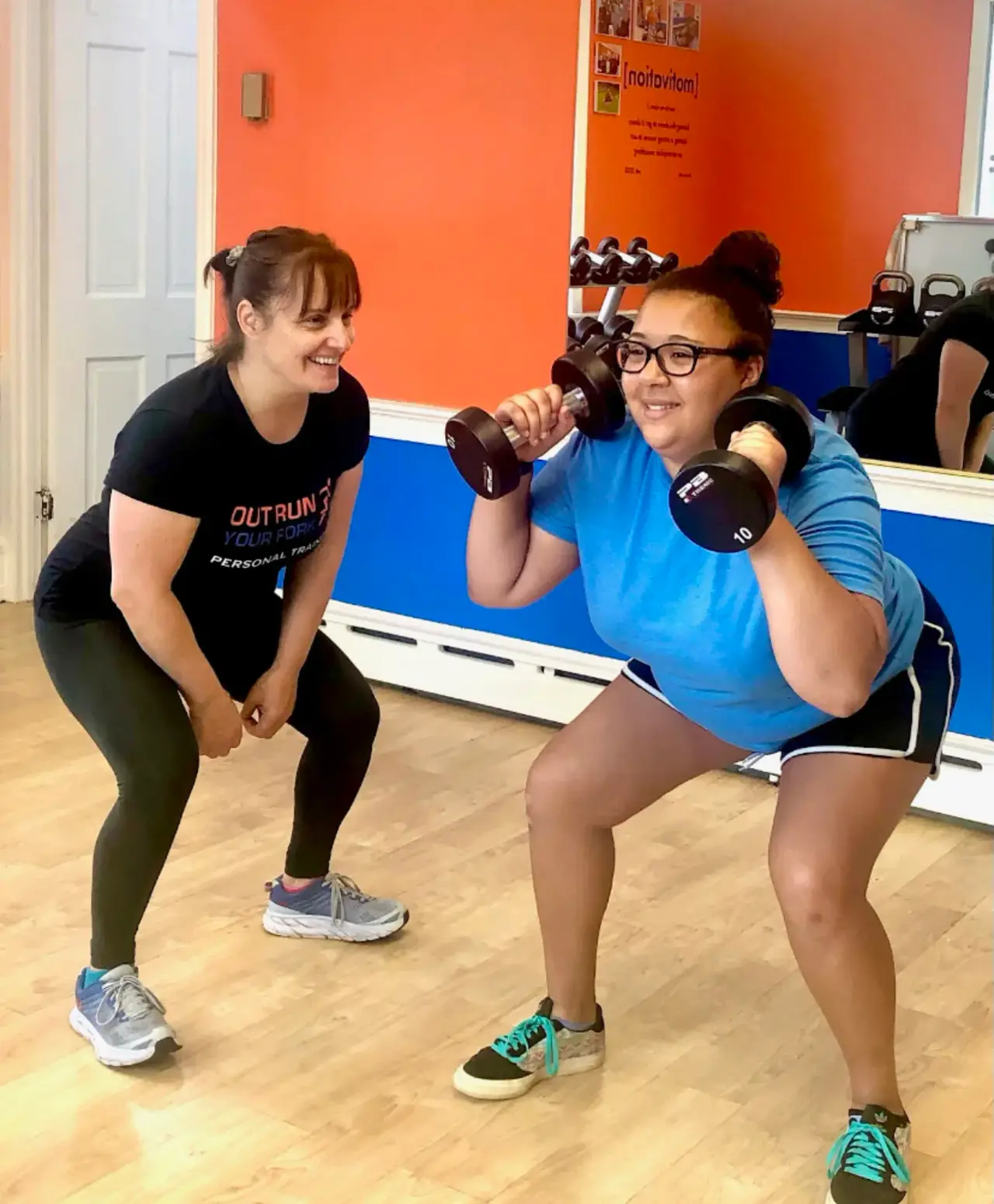 Two members training together with dumbbells
