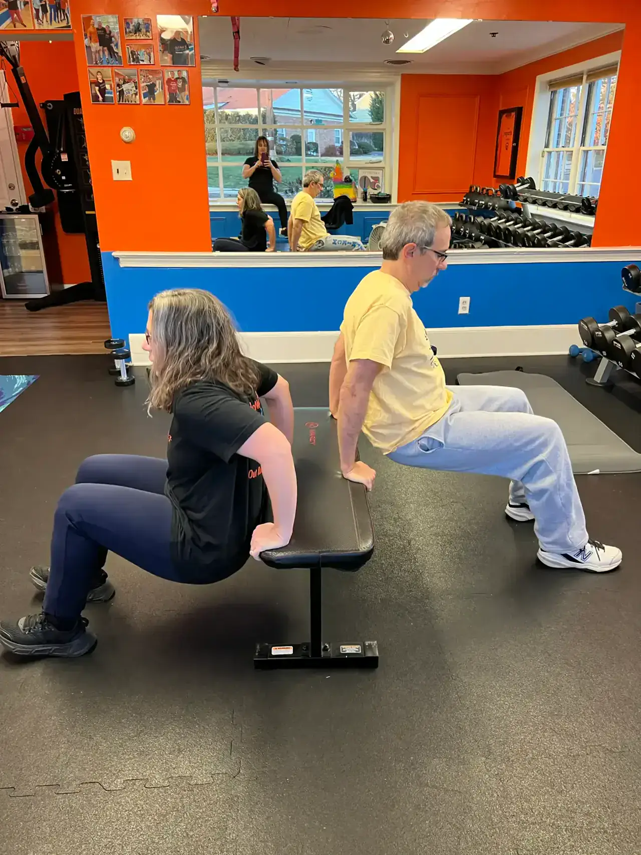A coach supporting an older member through a seated exercise